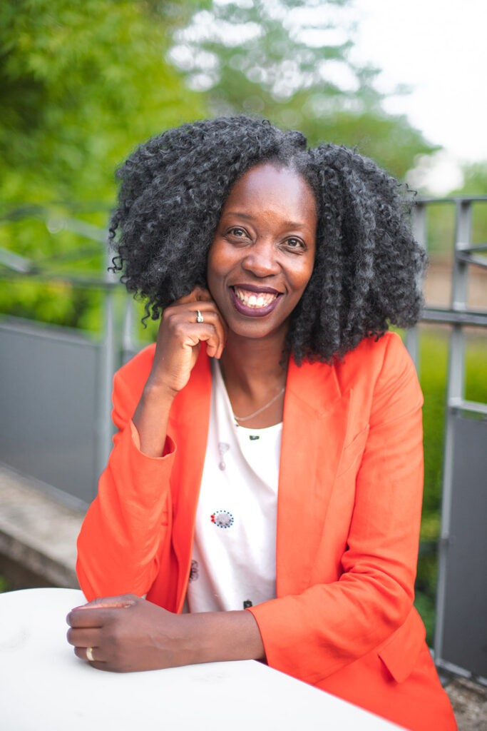 Portrait de Rosine Bassène, fondatrice de Carrières et Transitions, souriante en veste orange lumineuse.