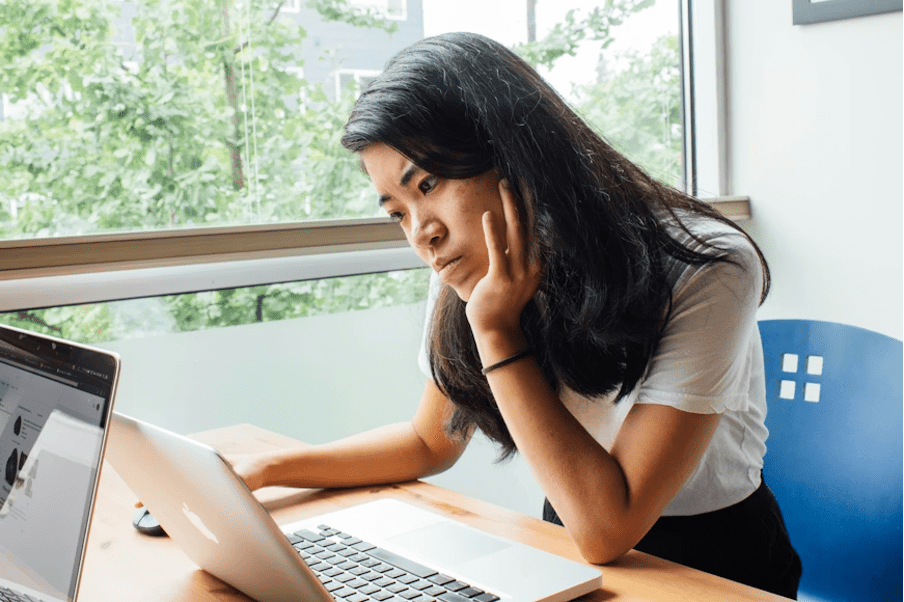 Femme entrepreneure devant son ordinateur réfléchissant à une collaboration inattendue