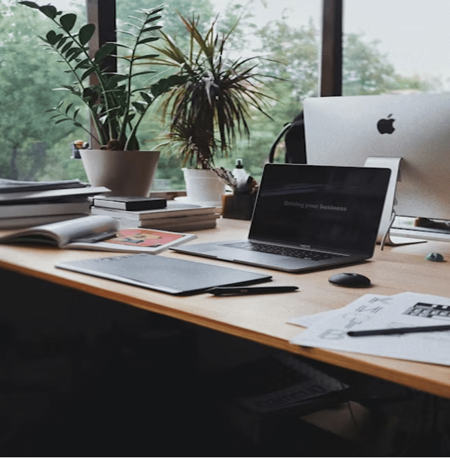 Espace de travail organisé avec un ordinateur portable, un carnet et des plantes vertes pour une session de deep work