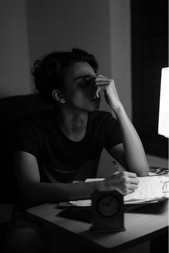 Dirigeante épuisée travaillant tard le soir à son bureau, incapable de fermer son ordinateur.